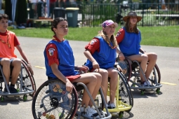 Jugendliche im Rollstuhl auf einem Sportplatz